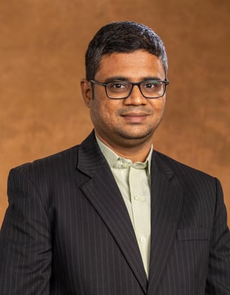 a man in a suit and glasses posing for a picture