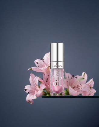 lip balm and flowers on grey background 
