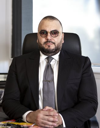 a man in a suit and tie sitting at a desk