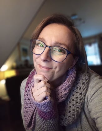 author d ann hall with glasses and a scarf around her neck