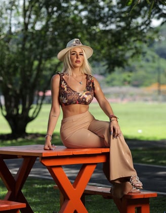 a woman in a bikini top sitting on a picnic table