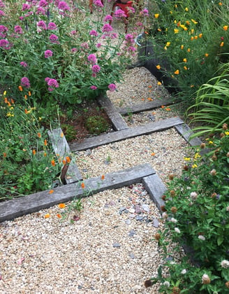 wood and gravel steps winding through colourful planting