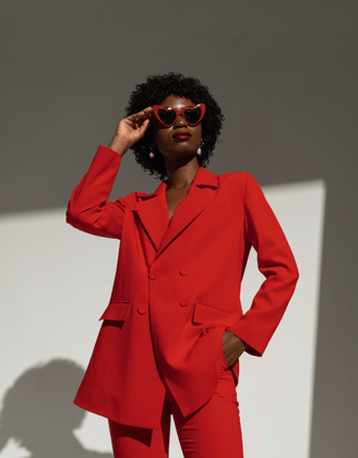 a woman in a red suit and sunglasses