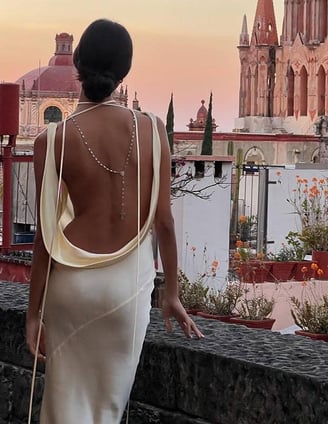 a woman in a white dress standing on a balcony