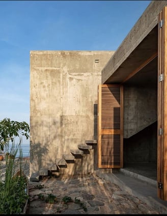 a concrete wall with stairs leading to a concrete house with wood features Rhodes Greece
