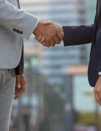 International business partners shaking hands to establish pharmacovigilance collaborationInternatio