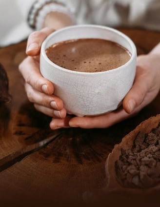 a person holding a cup of cacao elixir