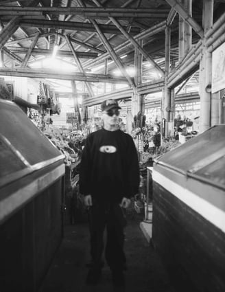 Hombre vestido de negro en plaza de mercado