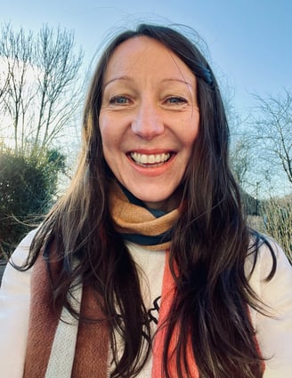 Olivia Harrison smiling with a blue sky behind her