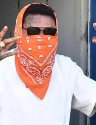 Vybz Kartel in a white shirt and dark spectacles.