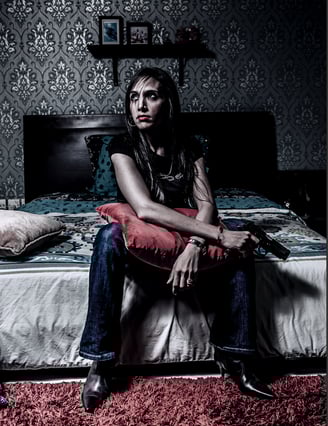 Cinematic portrait of woman with a gun, dramatic lighting, moody bedroom, fine art conceptual photo