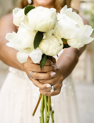 Bridal bouquet held by the bride with a soft-focus smile in the background, Provence elopement