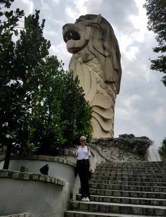 Lady poses beneath the Sentosa Merlion in Singapore