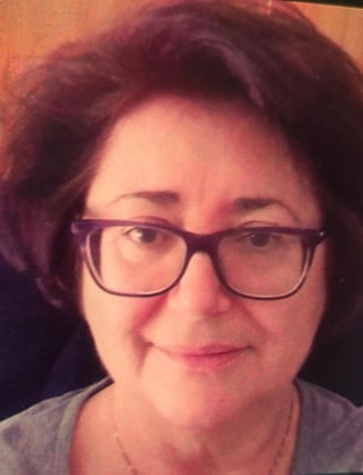 a woman with glasses and a necklace on her neck