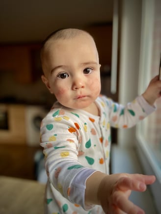 a baby is standing in front of a window