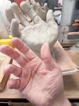 Lode sculpteure prend pour modèle sa main pour modeler une main en argile