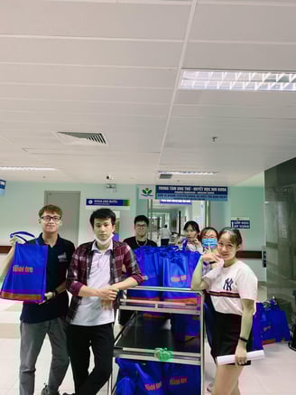 a group of people standing around a carton