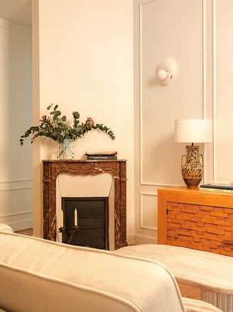 Salon haussmannien rénové à Paris avec cheminée ancienne et buffet en bois sculpté, vintage