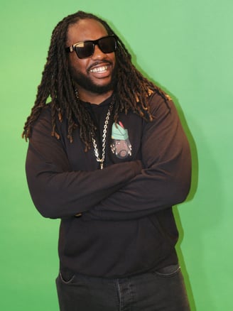 a man with dreadlocks and sunglasses on a green background