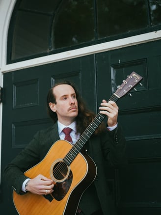a man in a suit and tie playing guitar