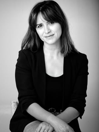 a business woman sitting on a chair with her hands on her knees
