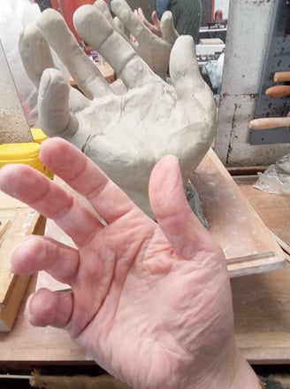 Lode sculpteure prend pour modèle sa main pour modeler une main en argile