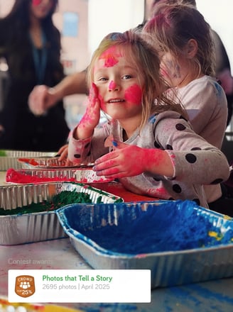 a young girl with her hands painted with red and blue paint holi