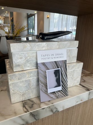paperback book tapes in drag: poetry & remorse leaning on luxurious boxes