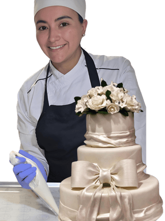 Natalia smiling while holding a beautifully decorated cake, showcasing her artisanal baking skills.