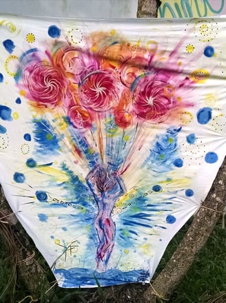 toile tendue entre deux arbes avec peinture représentant un corps s'envolant emmené par des genre de ballons 