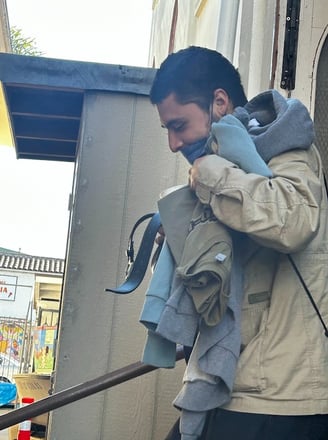 Man smiling through a face mask getting clothes
