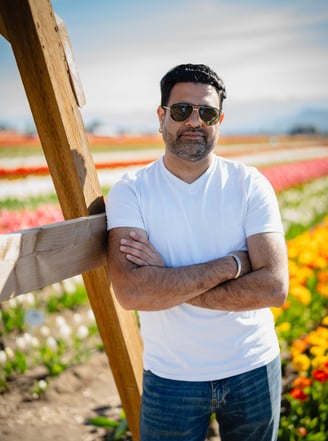 a man in sunglasses and standing in front of a wooden cross
