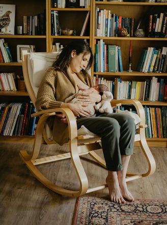 Maman qui allaite à domicile dans un fauteuil à bascule – séance photo Gard