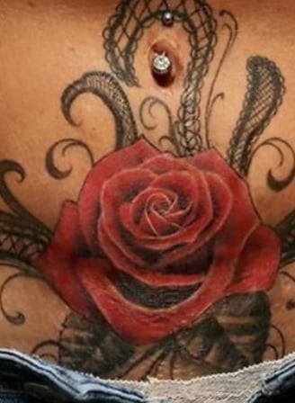 tattoo of a red rose on a womens lower abdomen