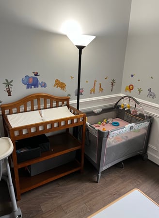 Photo of daycare room. Changing table and infant bed.