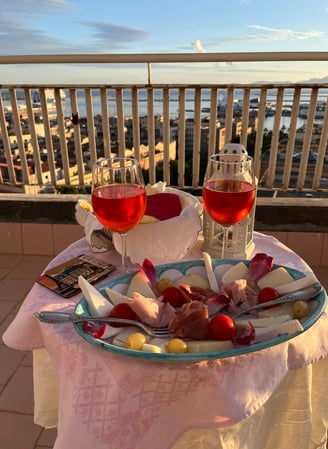 a table with a plate of food and wine glasses