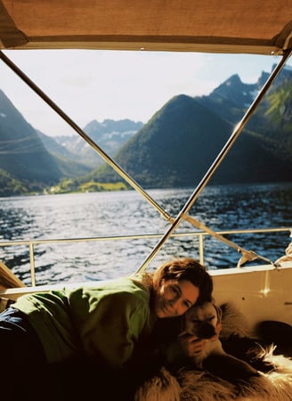 elaxing moment at sea—guest and dog enjoying a peaceful break on board in the Norwegian fjords.