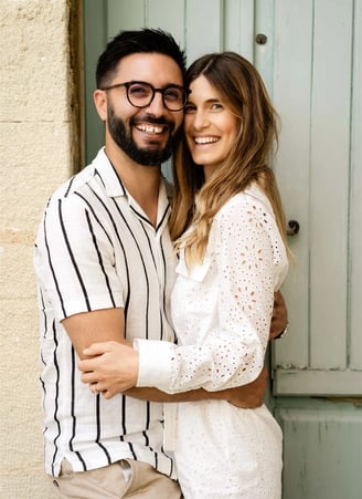 Smiling couple in front of an old door — fine art portrait in a Provençal village