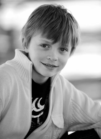 A young boy with a smile on his face photographed by Peter Pickering