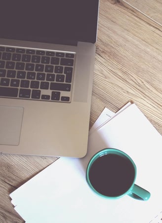 Une tasse de café et un PC sur bureau pour illustrer la page Contact de Kreskin