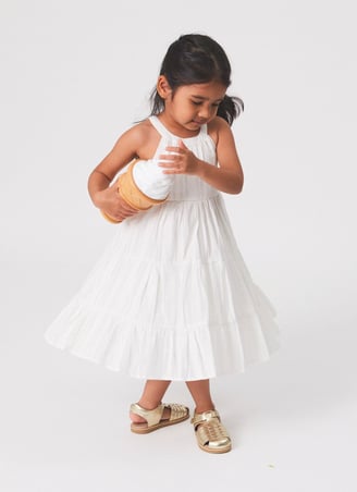 Fashion photography - a young girl in a white dress holding an icecream
