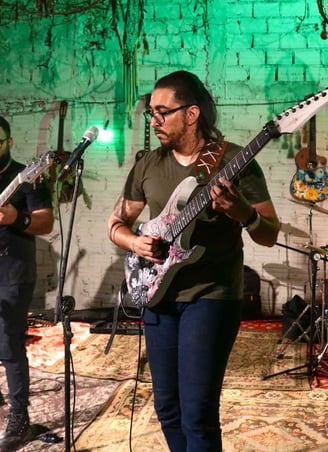 Anderson Alerrandro tocando guitarra durante a performance da Banda Onacra.