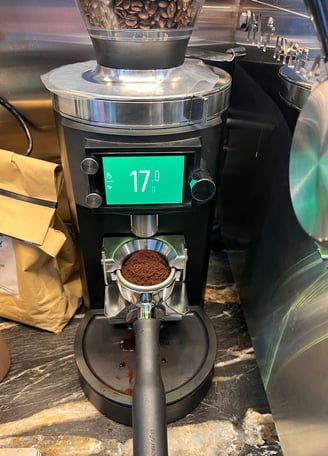 Precision coffee grinder dosing 17 grams of espresso directly into a portafilter.