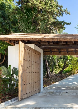 Entrance gates of Villa La Gratitud, framed by manicured greenery.