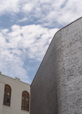 a brick clad building next to a white heritage building