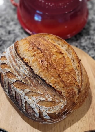 Freshly baked artisan sourdough bread on wooden board