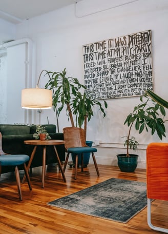 Decoração que une a natureza ao design, com plantas, iluminação e quadros bem posicionados.