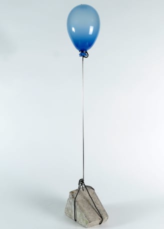 a blue balloon with a blue balloon attached to a rock