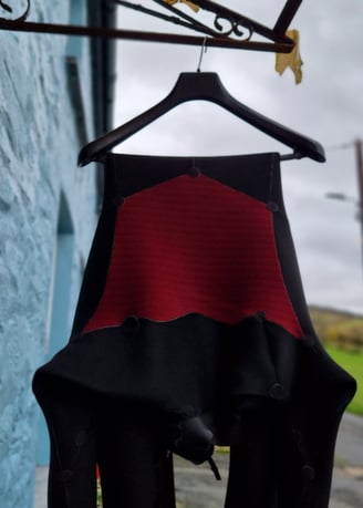 A wetsuit hanging up to dry on a clothes hanger