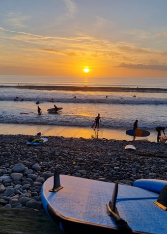 Beautiful sunset at Ynyslas with surfboard fins and busy surf lesson